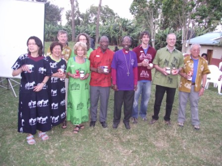 Team in Tanzanian costumes with Bishop Mwita in a T-shirt given by the team